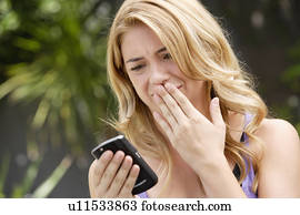 Young woman text-messaging, with facial expression