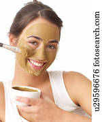 Woman applying healing earth face mask