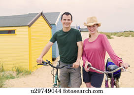 Happy couple on beach with bicycles Happy couple on beach with bicycles
