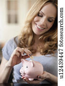 Woman saving money in piggy bank