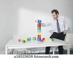 Business man playing with blocks