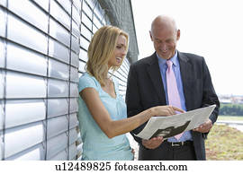 Business people reading newspaper