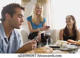 Smiling people at home party playing cards