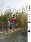 Mother and daughter walking in pond