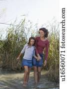 Mother and daughter walking in pond