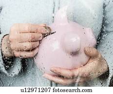 Woman saving money at rainy window