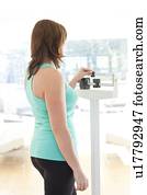 Woman weighing herself.