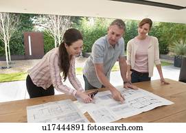 Business people reading blueprints