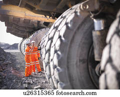 Workers examining trucks in coal mine
