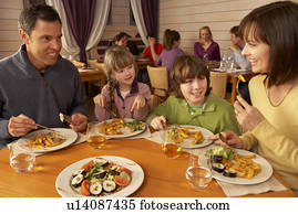 Family Eating Lunch Together In Restaurant Family Eating Lunch Together In Restaurant