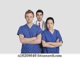 Portrait of confident healthcare workers standing over gray background