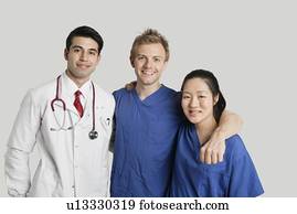 Portrait of friendly medical team standing over gray background