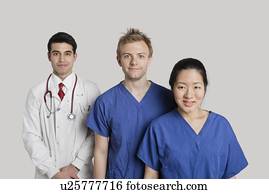 Portrait of happy medical team standing over gray background