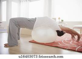 Mid adult men exercising with fitness ball