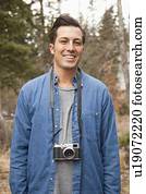 Portrait of young man with old fashioned camera in non-urban scene