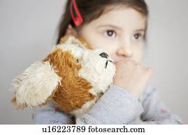 girl hugging a teddy bear