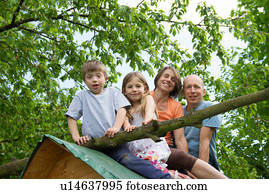 Family with two children sitting on playhouse roof