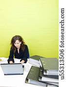 Caucasian young woman working on her laptop computer at her desk