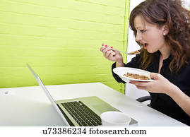 Close up of woman eating at her desk