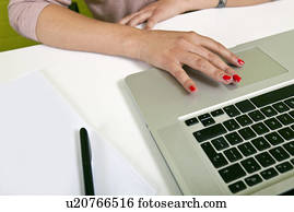 Close up of womans hands typing on laptop