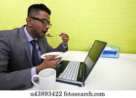 Indian businessman eating at his desk