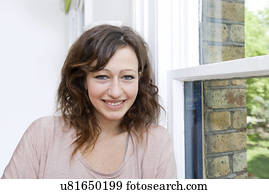 Young woman in trendy office looking at camera and smiling