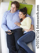 Overhead View Of Couple Watching TV On Sofa