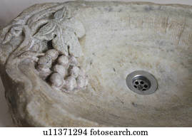 Detail grapes carved out of stone sink