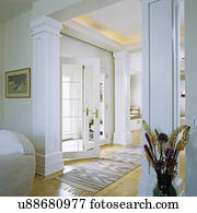 Entry halls: white French doors open into entrance hall from small foyer, light stained wood floors, four columns add formality, arts and craft style, southwestern theme rug Entry halls: white French doors open into entrance hall from small foyer, light stained wood floors, four columns add formality, arts and craft style, southwestern theme rug