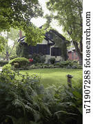 EXTERIORS: Lush shaded front yard of city bungalow with Arts and Crafts influence, shutters and  stucco, vertical version