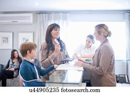 Mother and son making payment at hospital reception