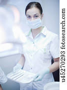 Portrait of female dental nurse holding surgical tray