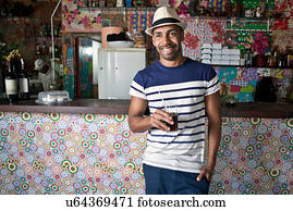 Man by counter of cafe bar with a drink