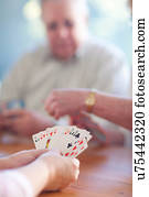 Senior male playing cards with family