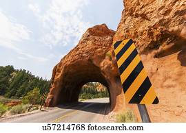 Road going under natural tunnel