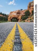 Road going under natural tunnel