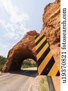 Road going under natural tunnel