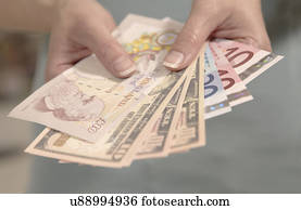 Female hands holding American, British and European currency