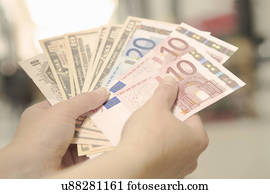 Female hands holding American, British and European bank notes