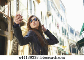 Girl taking selfie on smartphone, Venice, Italy