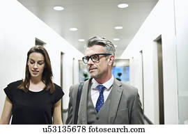 Business colleagues walking along office corridor