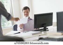 Man with down syndrome working in office