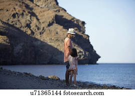 Father and daughter standing by the sea, Costa Brava, Catalonia, Spain