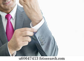 Midsection of mature businessman buttoning sleeve