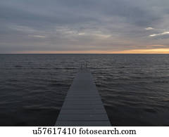Pier, sea and sunrise over horizon