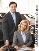 People working in car showroom