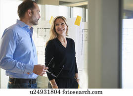 Architects standing by plans on glass wall
