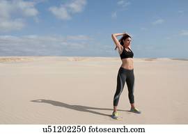 Mid adult woman exercising on beach