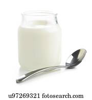 Jar of fresh yoghurt and a spoon against a white background.