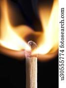 Matchstick on fire against a black background.